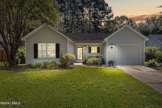 single story home with a garage and a yard