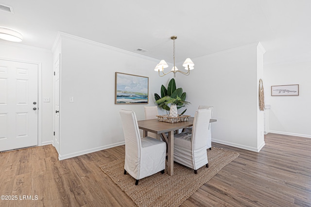 3017 Magnolia St, Beaufort, SC 29906 - dining space with wood finished floors, a chandelier, baseboards, and crown molding