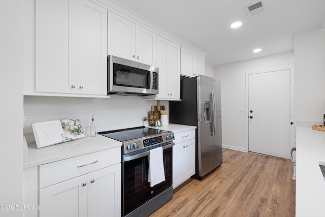 3017 Magnolia St, Beaufort, SC 29906 - kitchen featuring stainless steel appliances, light countertops, white cabinets, light wood-style floors, and recessed lighting