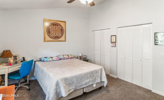 carpeted bedroom with vaulted ceiling, two closets, and ceiling fan