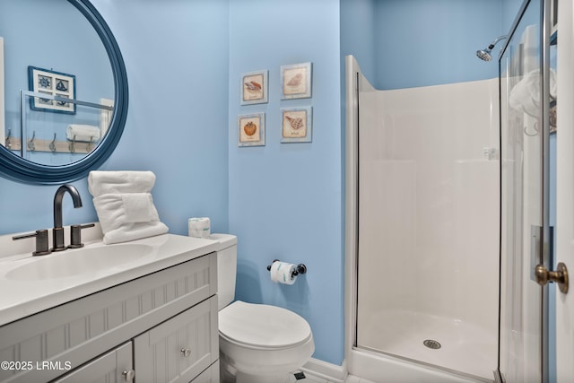 bathroom with toilet, vanity, and a stall shower