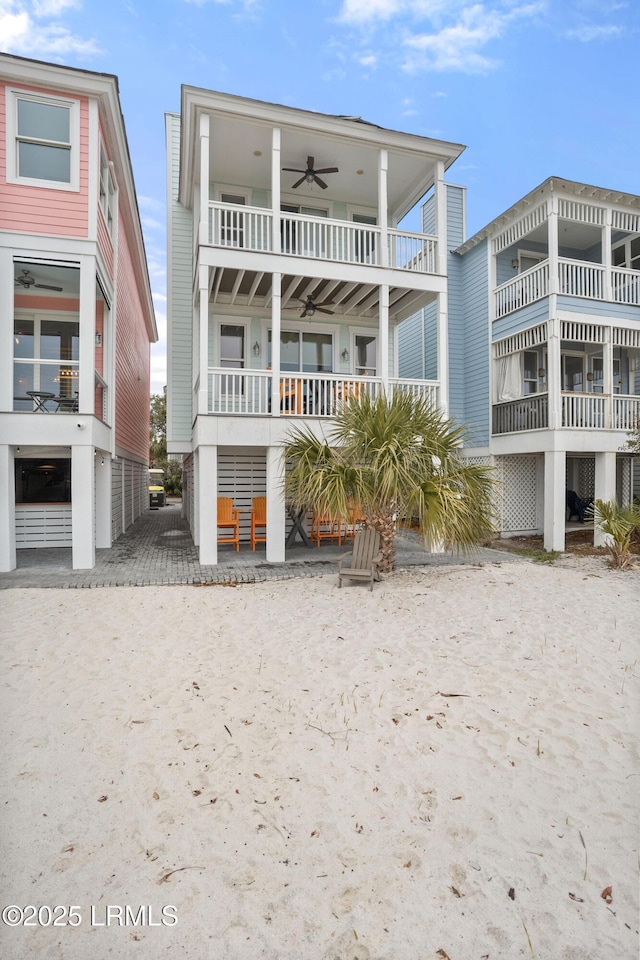 rear view of property with a ceiling fan and a balcony