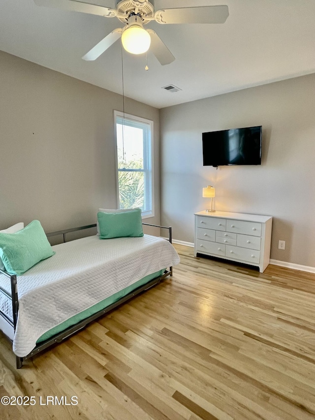 bedroom with light wood-type flooring, visible vents, baseboards, and ceiling fan