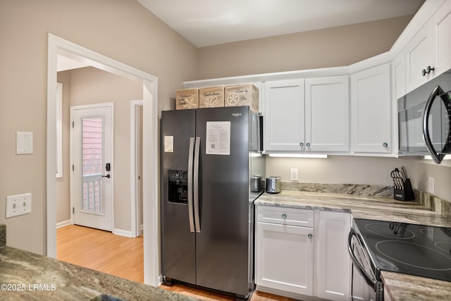 kitchen with white cabinets, stainless steel fridge with ice dispenser, black microwave, light wood-type flooring, and electric range oven