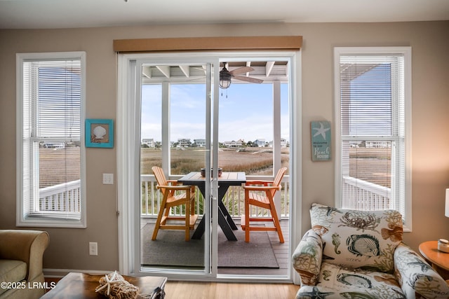 doorway with light wood-style flooring and a ceiling fan
