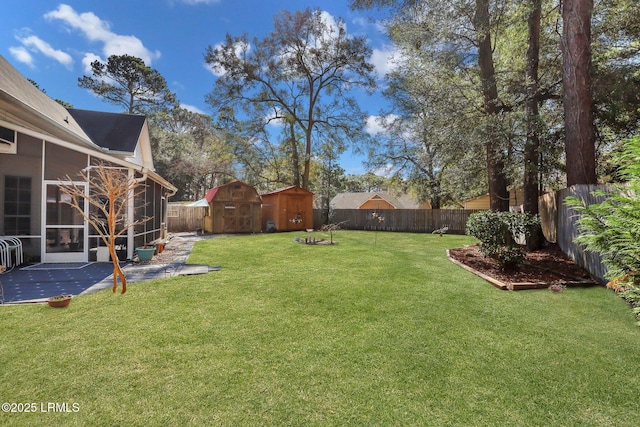 view of yard with a patio, a sunroom, a shed, a fenced backyard, and an outdoor structure