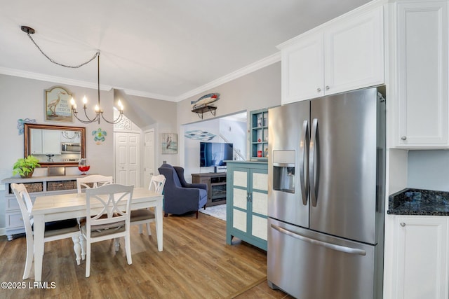 kitchen with appliances with stainless steel finishes, white cabinetry, crown molding, and light wood-style flooring