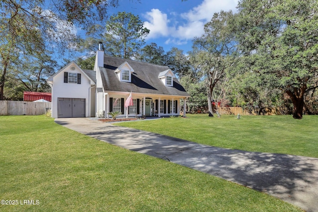 new england style home with driveway, a chimney, covered porch, fence, and a front yard