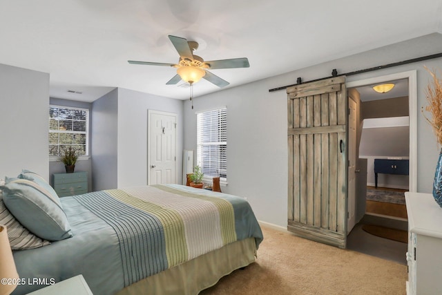 bedroom with light carpet, a barn door, visible vents, and ceiling fan