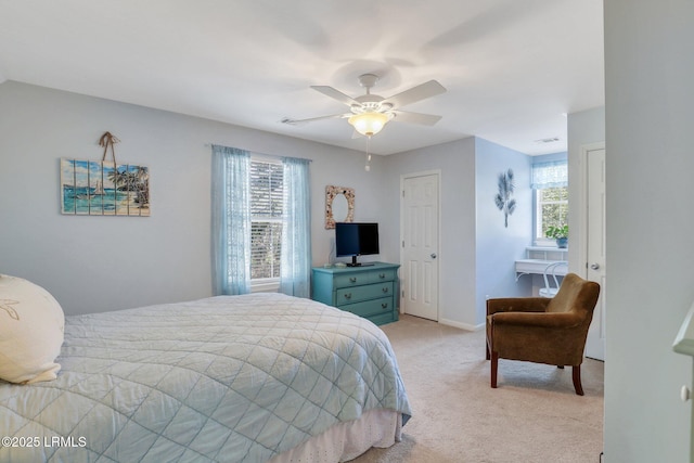 bedroom featuring light carpet, ceiling fan, multiple windows, and baseboards