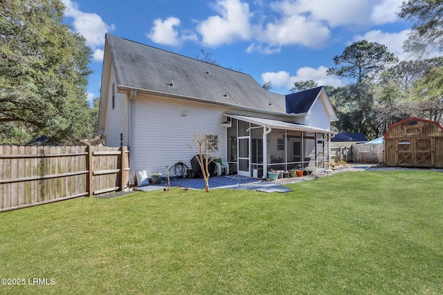 back of house featuring a sunroom, a fenced backyard, and a lawn