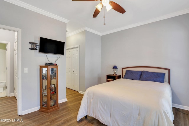 bedroom with ceiling fan, wood finished floors, baseboards, a closet, and crown molding