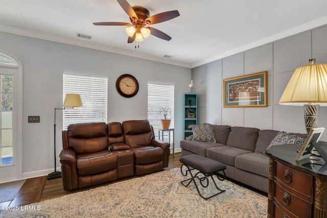 living room featuring plenty of natural light, dark wood finished floors, visible vents, and crown molding