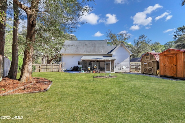 rear view of property with a lawn, a sunroom, a fenced backyard, an outdoor structure, and a shed