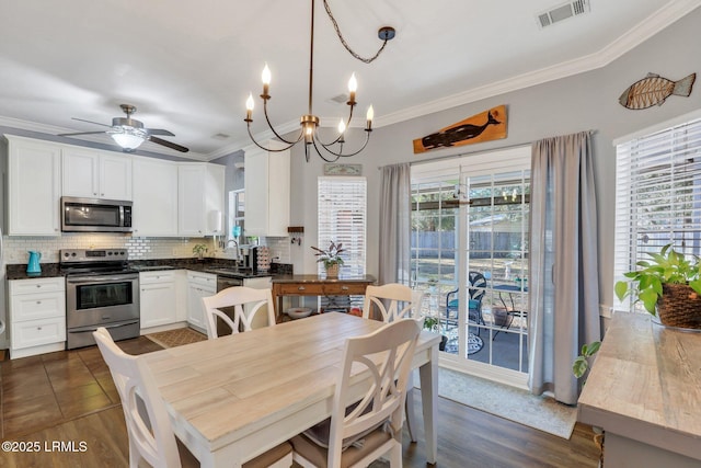 kitchen with decorative light fixtures, dark countertops, visible vents, appliances with stainless steel finishes, and white cabinetry