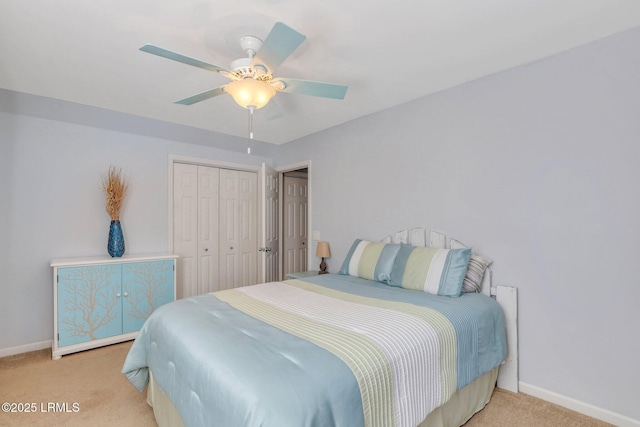 bedroom featuring baseboards, ceiling fan, a closet, and light colored carpet