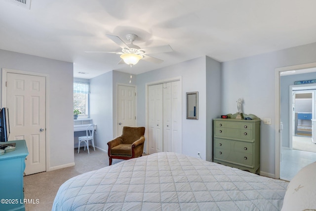 bedroom featuring a ceiling fan, a closet, light colored carpet, and baseboards