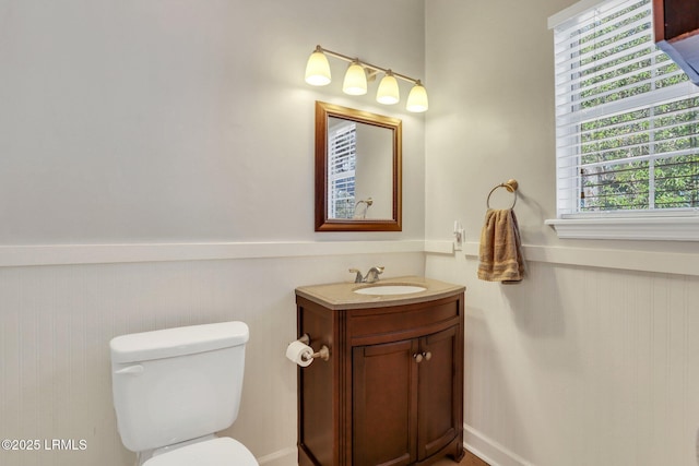 bathroom featuring a wainscoted wall, vanity, and toilet