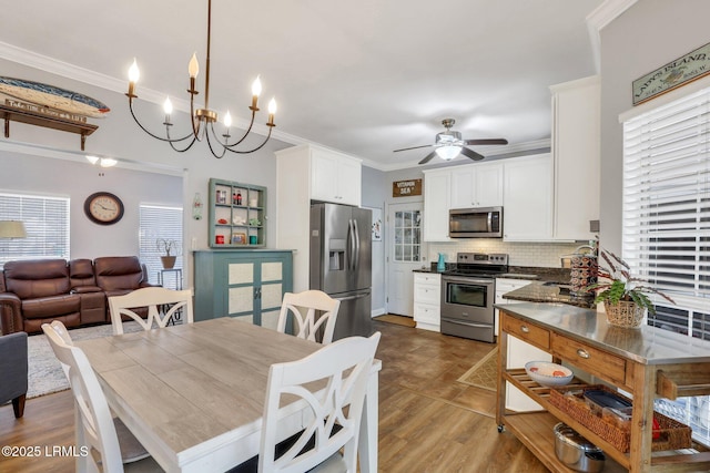 dining room with ceiling fan, ornamental molding, and a healthy amount of sunlight