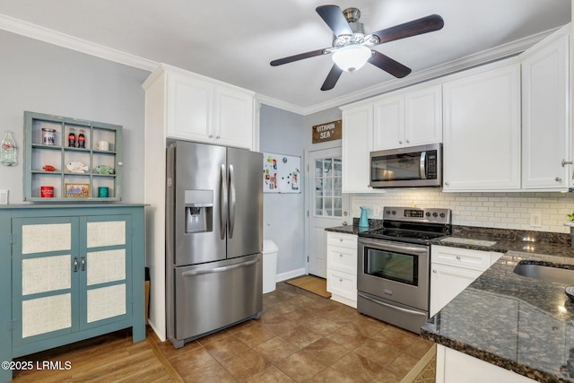 kitchen featuring tasteful backsplash, appliances with stainless steel finishes, ornamental molding, white cabinetry, and a sink