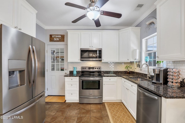 kitchen with visible vents, stainless steel appliances, crown molding, white cabinetry, and a sink