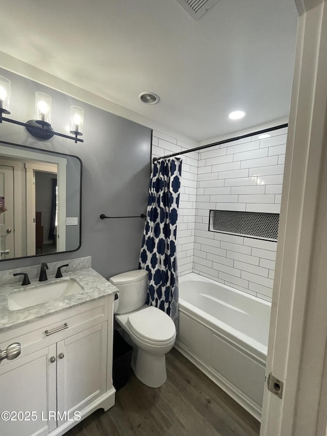 full bathroom featuring vanity, wood-type flooring, shower / bath combination with curtain, and toilet