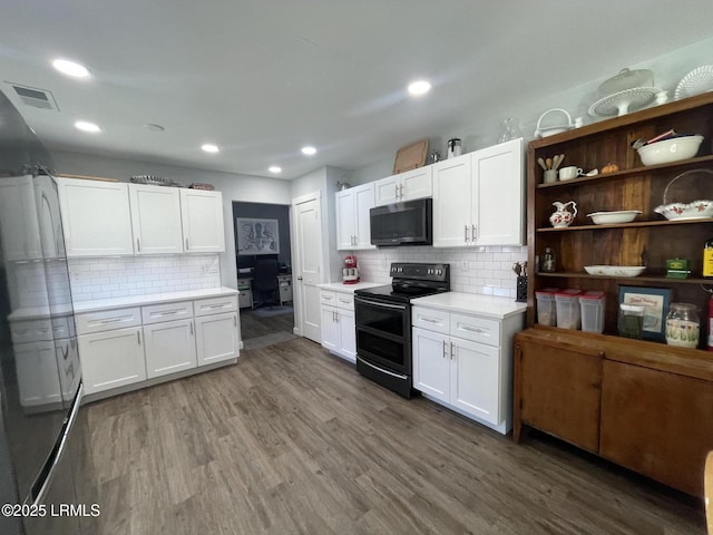 kitchen featuring range with two ovens, white cabinetry, dark hardwood / wood-style floors, and decorative backsplash