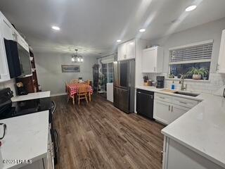 kitchen with refrigerator, dishwasher, sink, and white cabinets