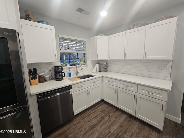 kitchen with white cabinets, stainless steel refrigerator, sink, and black dishwasher