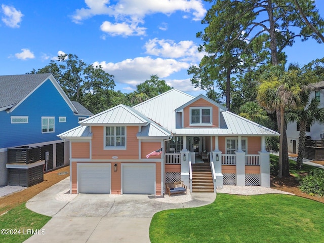 view of front of property featuring a garage, covered porch, and a front lawn