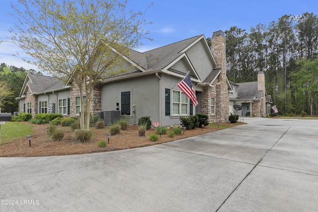 1034 Abbey Glen Way, Hardeeville, SC 29927 - view of side of home with concrete driveway, stucco siding, a chimney, and stone siding
