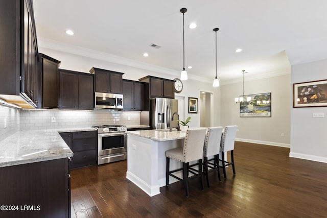 1034 Abbey Glen Way, Hardeeville, SC 29927 - kitchen featuring dark brown cabinetry, a kitchen breakfast bar, dark wood-style floors, backsplash, and stainless steel appliances