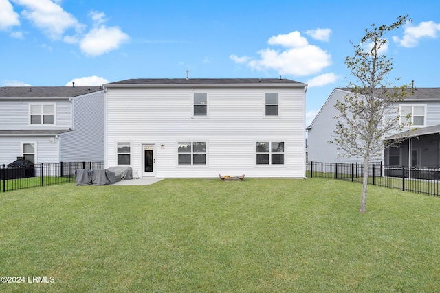 back of house with a patio area and a lawn