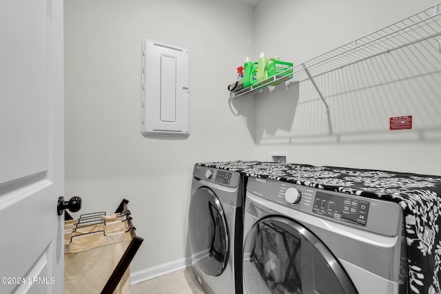 laundry room with tile patterned flooring, electric panel, and washer and dryer