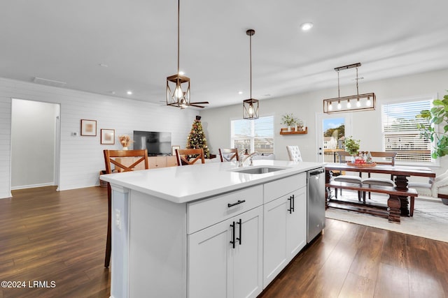 kitchen with sink, dishwasher, hanging light fixtures, an island with sink, and white cabinets