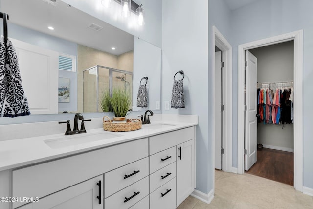 bathroom featuring walk in shower, tile patterned floors, and vanity