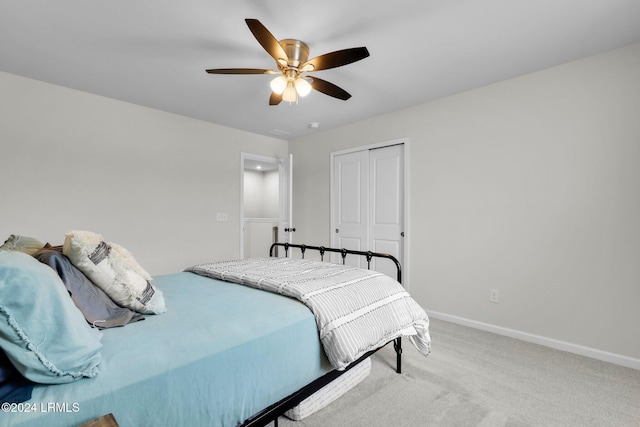 bedroom with ceiling fan, a closet, and light carpet