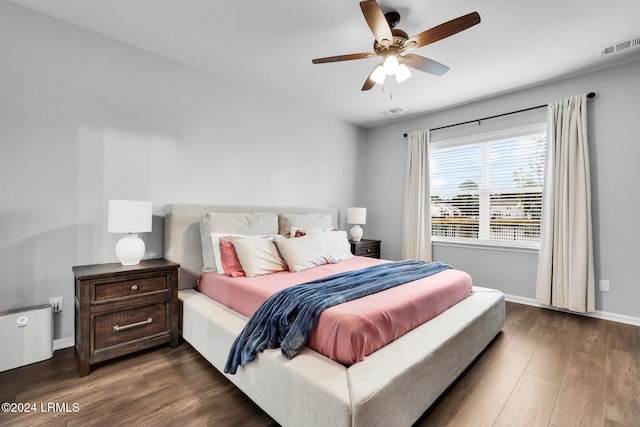 bedroom with dark hardwood / wood-style floors and ceiling fan