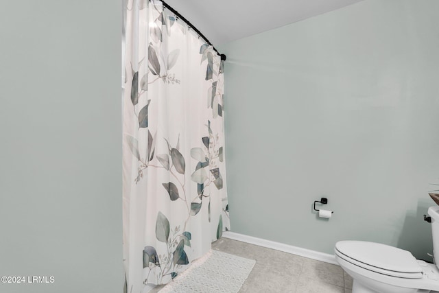 bathroom featuring tile patterned flooring, a shower with curtain, and toilet