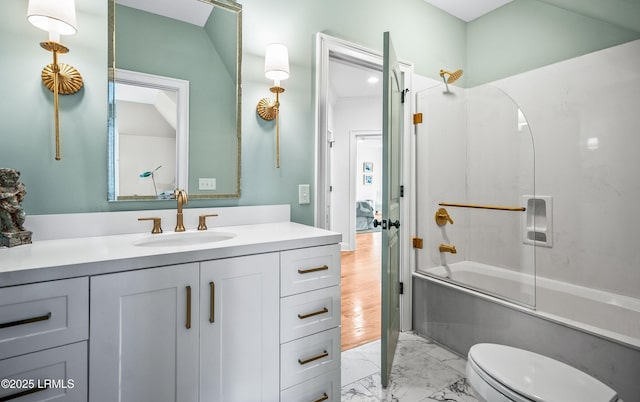 full bathroom featuring toilet, marble finish floor, shower / bath combination with glass door, and vanity