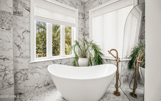 bathroom with a healthy amount of sunlight and a freestanding bath