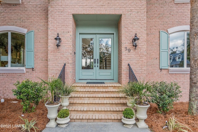 entrance to property featuring french doors and brick siding