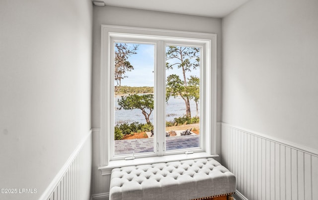 entryway with a wainscoted wall and a water view