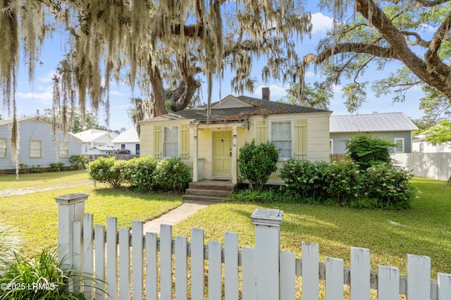2307 Depot Rd, Beaufort, SC 29902 - bungalow-style home featuring a fenced front yard, a chimney, and a front lawn