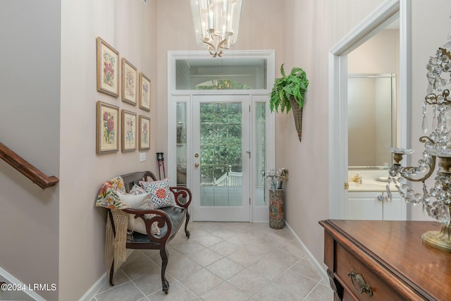 doorway to outside featuring light tile patterned flooring and an inviting chandelier