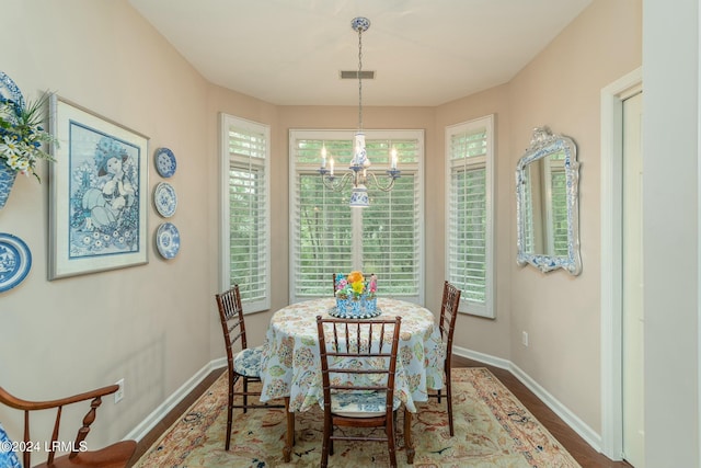 dining area with dark hardwood / wood-style floors and a notable chandelier