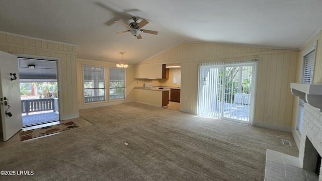 unfurnished living room with visible vents, lofted ceiling, light colored carpet, and ceiling fan with notable chandelier