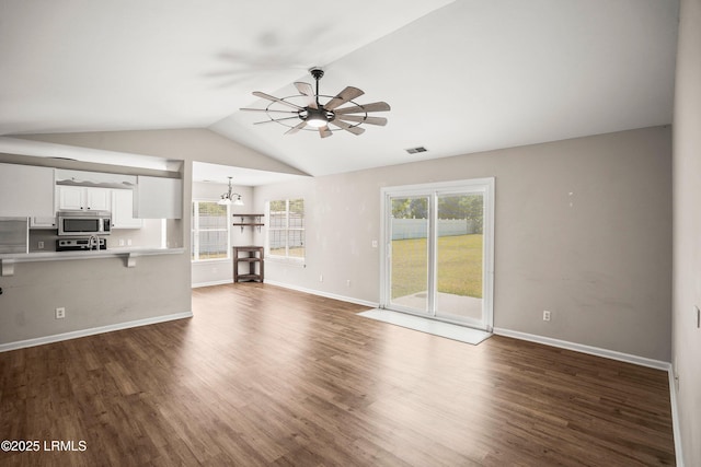 2718 Waddell Rd, Beaufort, SC 29902 - unfurnished living room with visible vents, vaulted ceiling, dark wood finished floors, baseboards, and ceiling fan with notable chandelier