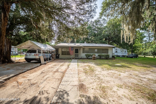 45 Youmans Dr, Ladys Island, SC 29907 - view of front of house with driveway, a carport, metal roof, a front lawn, and view of wooded area
