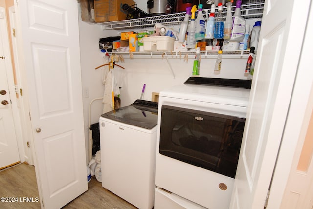 washroom with washing machine and dryer and light hardwood / wood-style floors